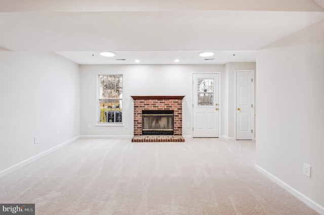 unfurnished living room with light carpet and a fireplace