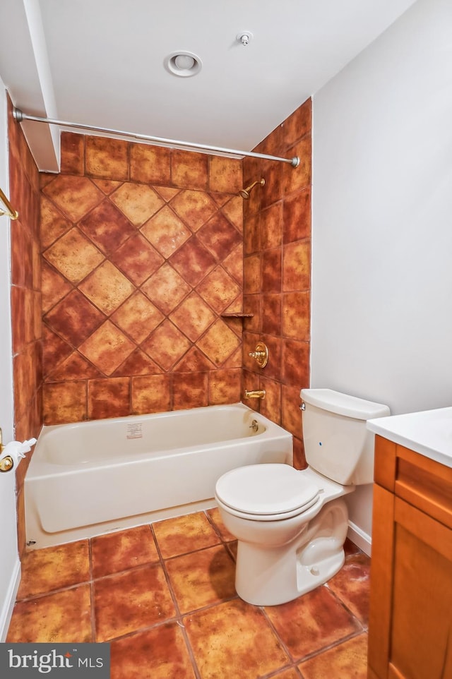 full bathroom with tile patterned floors, tiled shower / bath, vanity, and toilet