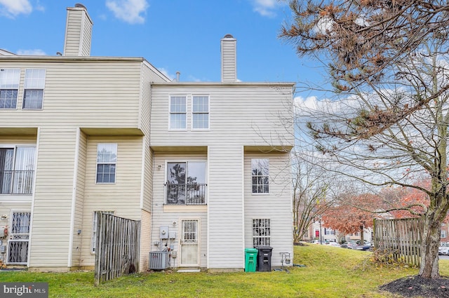 back of house with a lawn and central air condition unit