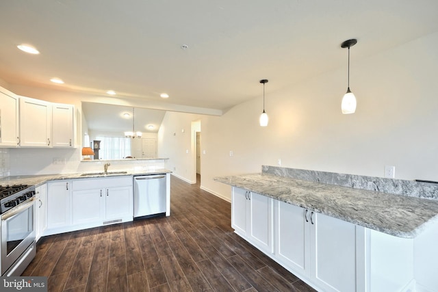 kitchen with kitchen peninsula, stainless steel appliances, white cabinetry, and lofted ceiling