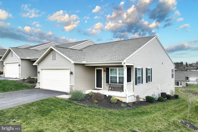 view of front facade featuring covered porch, a garage, central AC, and a front lawn