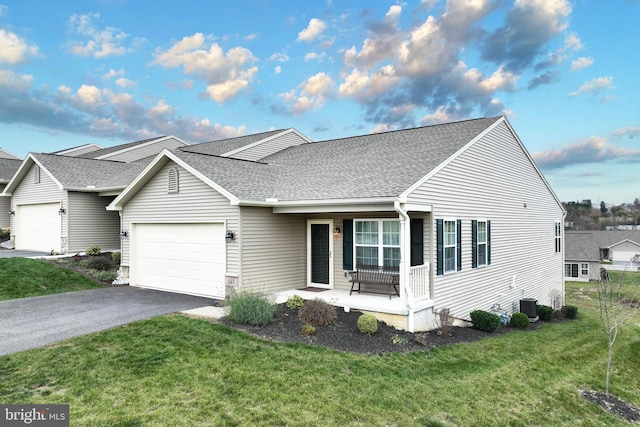 223 Jutland Way Unit 266, Red Lion, PA 17356 - view of front of home with covered porch, a garage, a front lawn, a shingled roof, and driveway
