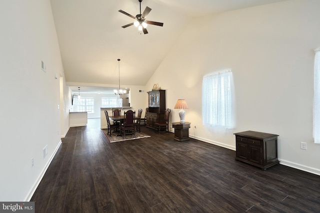 interior space with dark hardwood / wood-style flooring, high vaulted ceiling, and ceiling fan with notable chandelier