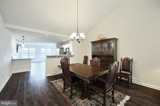 dining space featuring lofted ceiling, dark wood-type flooring, and a chandelier