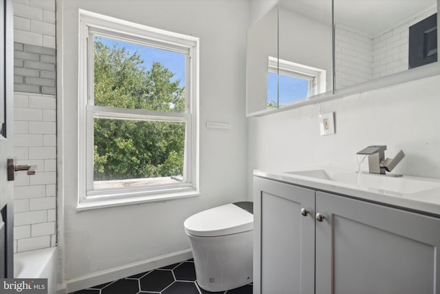 full bathroom featuring tiled shower / bath, vanity, and toilet