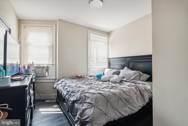 bedroom with vaulted ceiling, multiple windows, cooling unit, and dark hardwood / wood-style floors