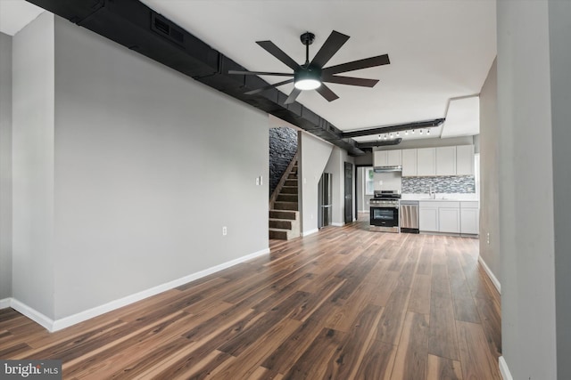 unfurnished living room with ceiling fan, sink, and hardwood / wood-style flooring