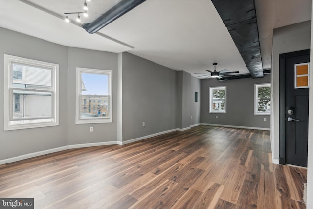 unfurnished living room with ceiling fan and dark hardwood / wood-style flooring