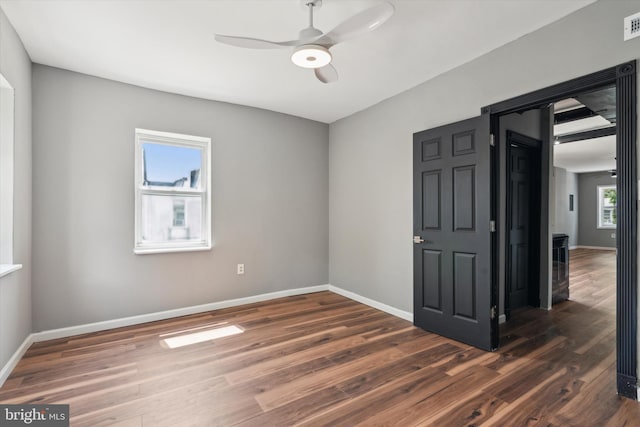 empty room featuring ceiling fan and dark hardwood / wood-style flooring