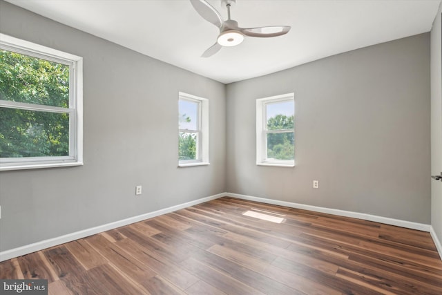 spare room featuring ceiling fan, dark hardwood / wood-style flooring, and a healthy amount of sunlight