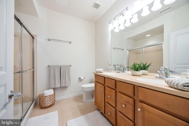 bathroom featuring toilet, vanity, tile patterned floors, and walk in shower