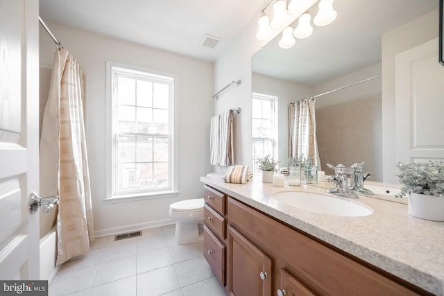 full bathroom with tile patterned floors, a wealth of natural light, vanity, and shower / tub combo