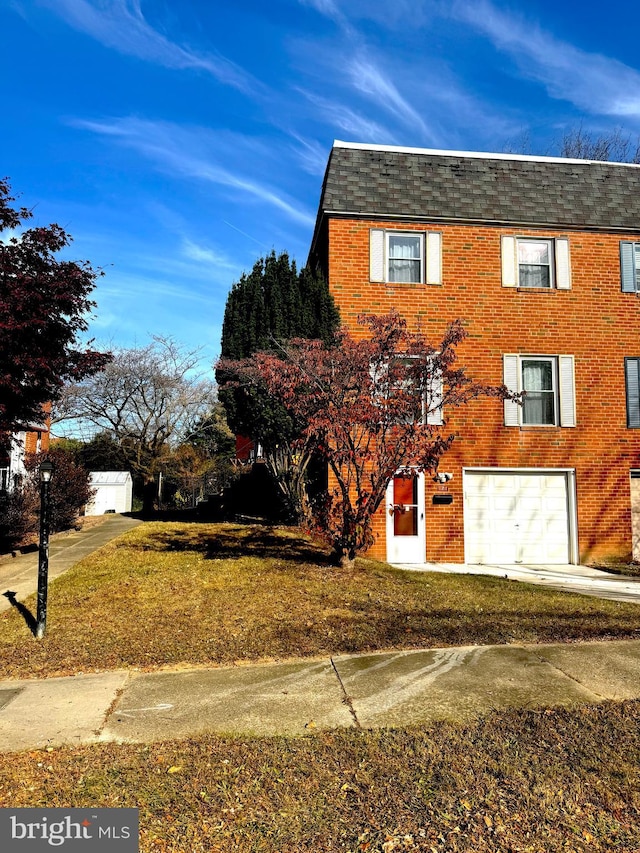 view of front of property featuring a front lawn and a garage