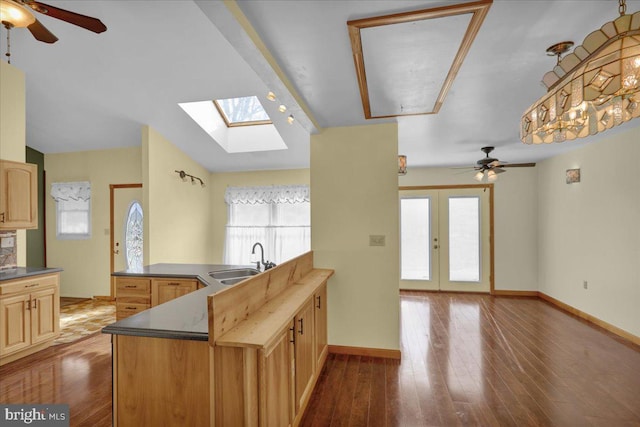 kitchen featuring ceiling fan, sink, light brown cabinets, kitchen peninsula, and hardwood / wood-style floors