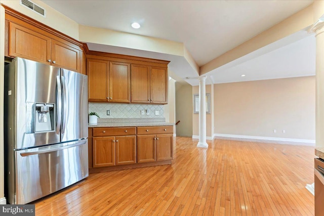 kitchen featuring ornate columns, stainless steel fridge, and light wood-type flooring