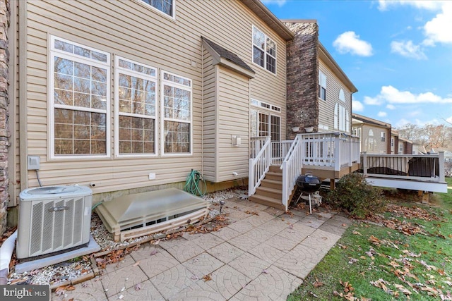 view of patio with central air condition unit, area for grilling, and a deck