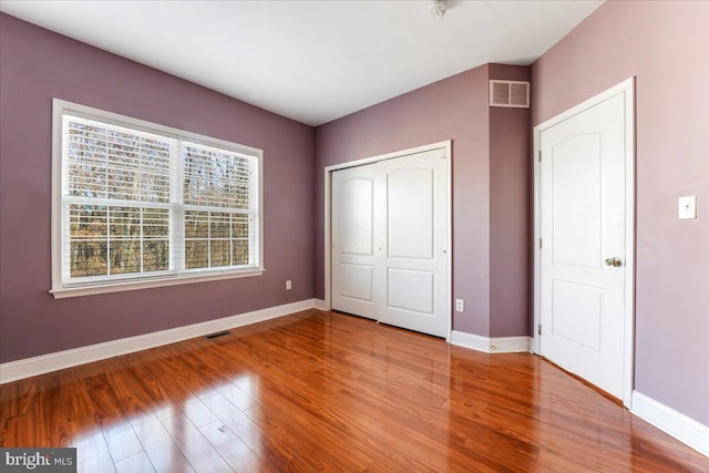 unfurnished bedroom with hardwood / wood-style floors and a closet