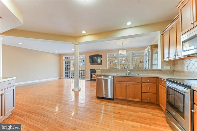 kitchen featuring pendant lighting, light hardwood / wood-style floors, sink, and stainless steel appliances