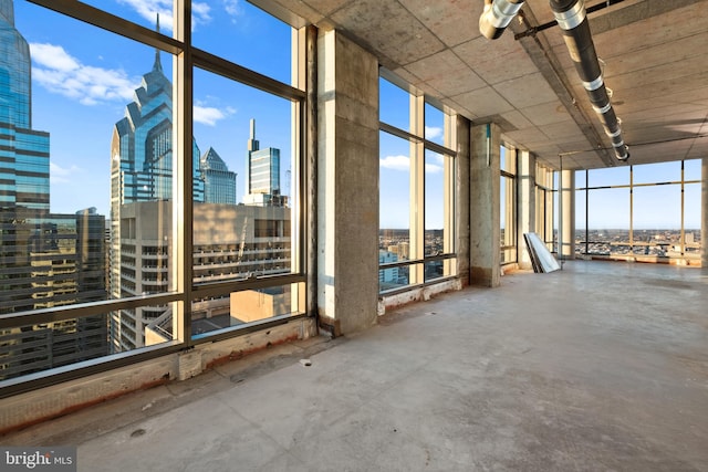 misc room featuring floor to ceiling windows and concrete flooring