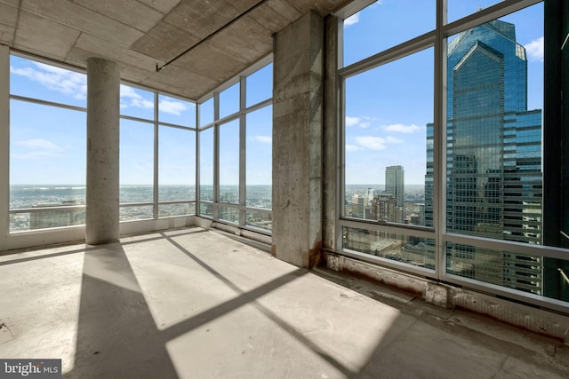 unfurnished sunroom with plenty of natural light and a water view