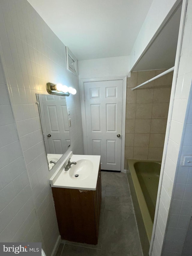 bathroom with vanity and tile walls