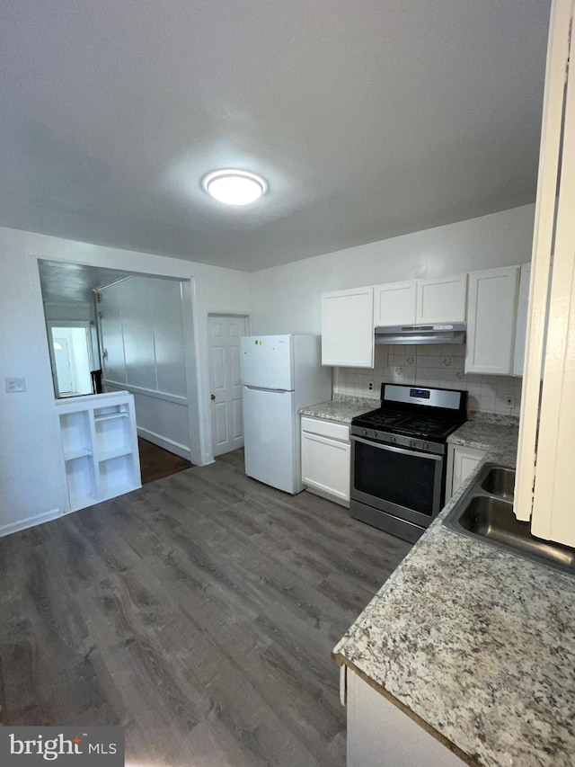 kitchen featuring dark hardwood / wood-style flooring, tasteful backsplash, stainless steel range oven, white cabinets, and white fridge