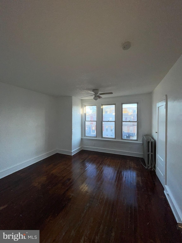 spare room featuring ceiling fan and dark wood-type flooring