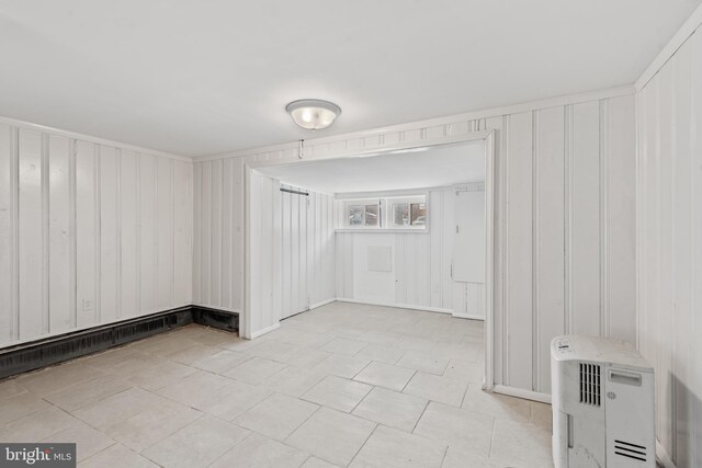 639 S Conkling St, Baltimore, MD 21224 - unfurnished living room with light tile patterned flooring, baseboards, and wood walls