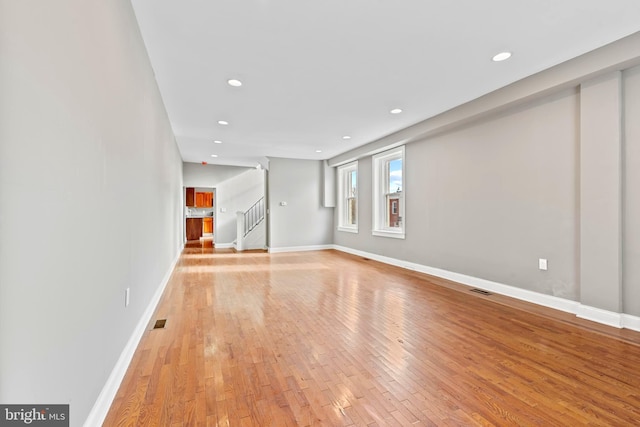 639 S Conkling St, Baltimore, MD 21224 - unfurnished living room featuring light wood-style flooring, stairs, recessed lighting, and baseboards