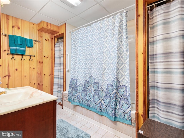 bathroom featuring vanity, tile patterned floors, a drop ceiling, and wooden walls