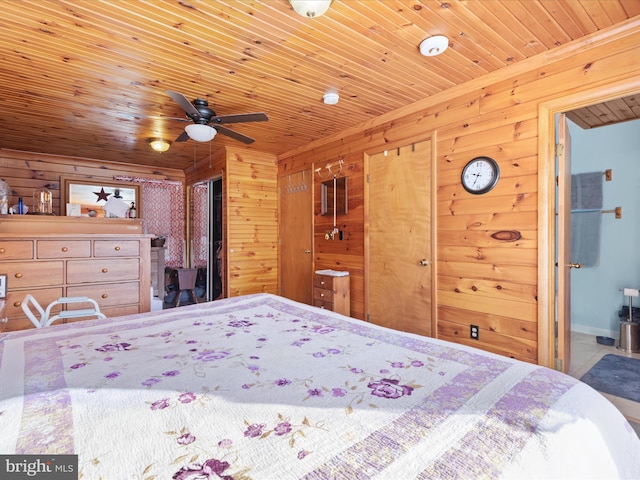 bedroom featuring wooden walls, ensuite bathroom, ceiling fan, and wooden ceiling