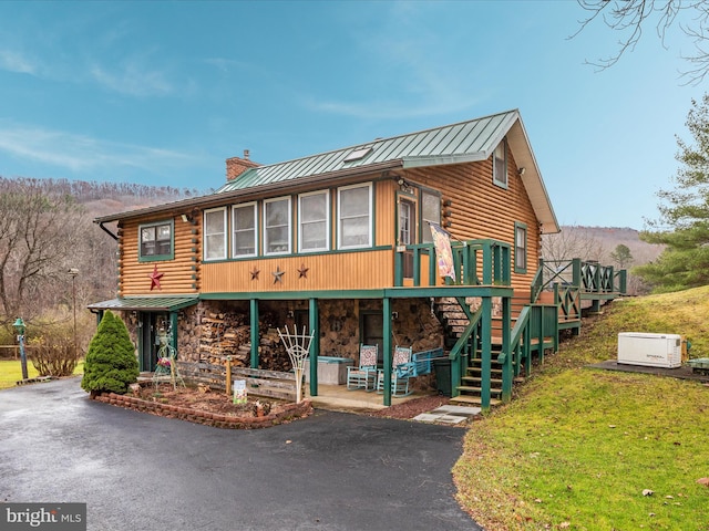 view of front of house with a patio area, a sunroom, and a wooden deck