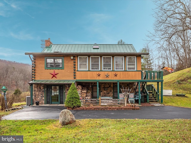 view of front of property with cooling unit and a front yard