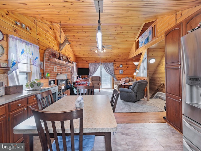 dining room with wood walls, lofted ceiling, wooden ceiling, ceiling fan, and light tile patterned floors