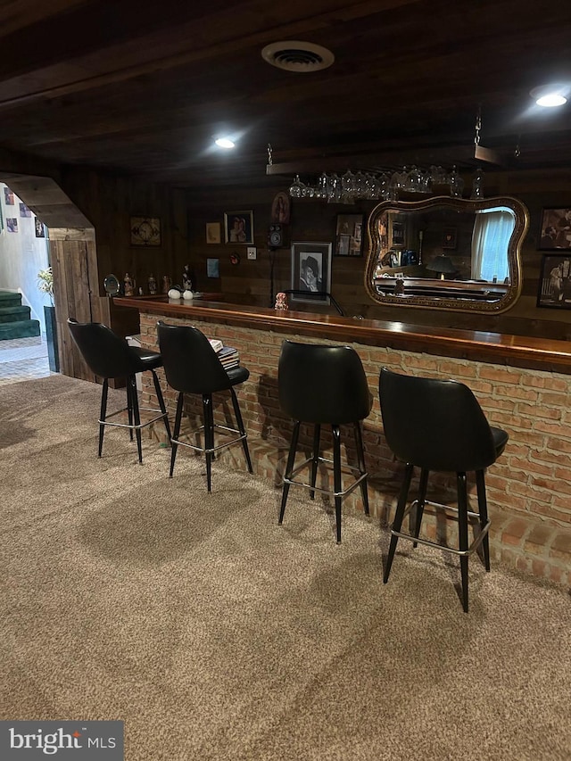 bar with carpet flooring and wood walls