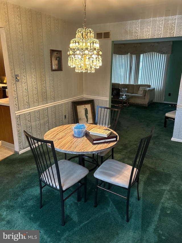 carpeted dining room with an inviting chandelier