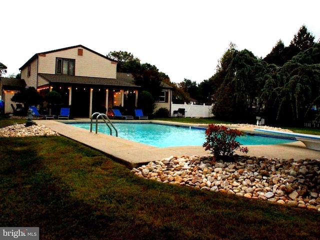 view of swimming pool featuring a patio area and a diving board