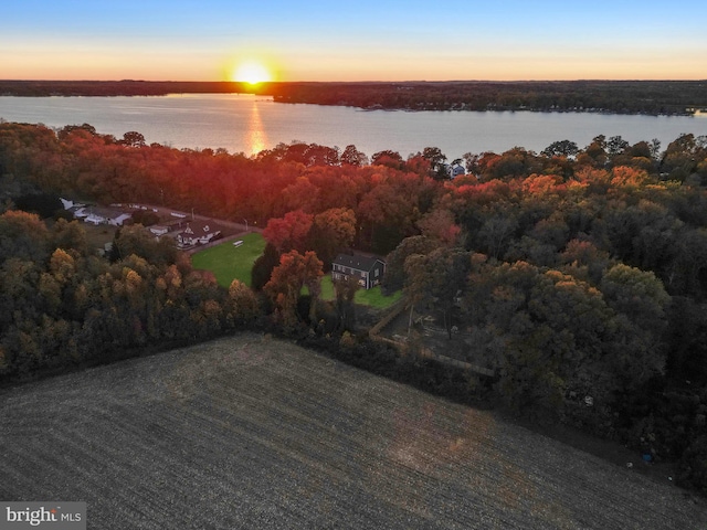 aerial view at dusk featuring a water view