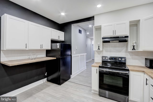 kitchen with white cabinetry, electric stove, black fridge, and butcher block counters