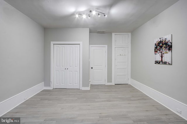 unfurnished bedroom featuring light wood-type flooring and a closet