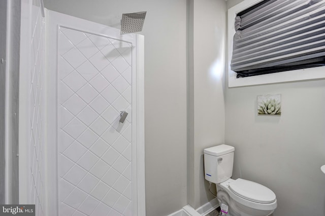 bathroom with toilet and tiled shower