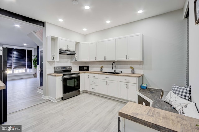 kitchen with white cabinets, tasteful backsplash, stainless steel electric stove, and sink