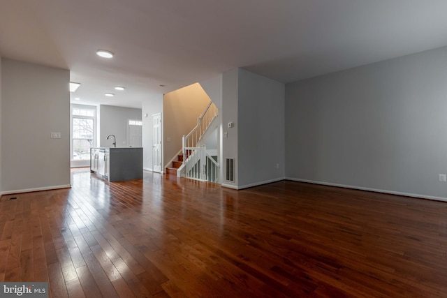 unfurnished living room with dark hardwood / wood-style floors and sink