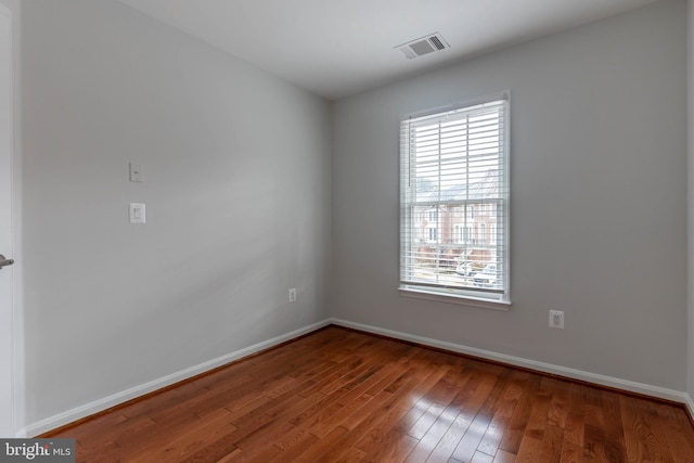 empty room with hardwood / wood-style floors and plenty of natural light