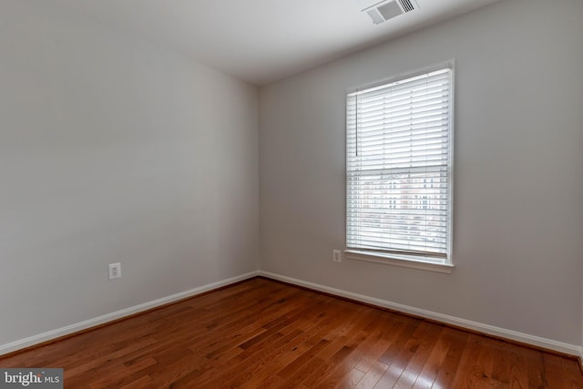 spare room with a healthy amount of sunlight and wood-type flooring