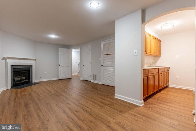 unfurnished living room featuring light hardwood / wood-style flooring and sink