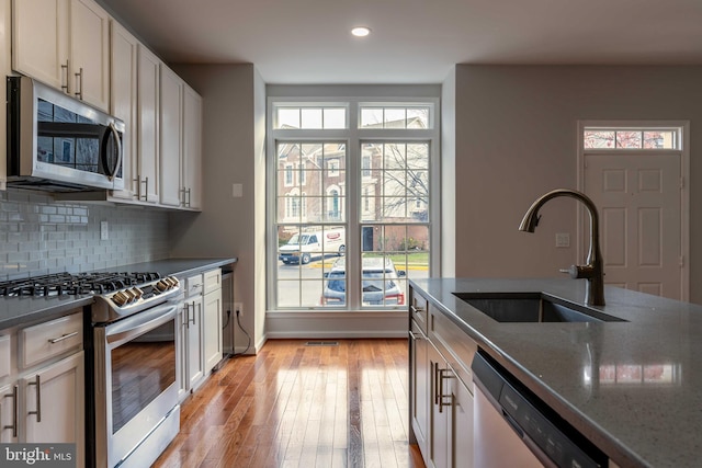 kitchen featuring a healthy amount of sunlight, sink, light wood-type flooring, and stainless steel appliances