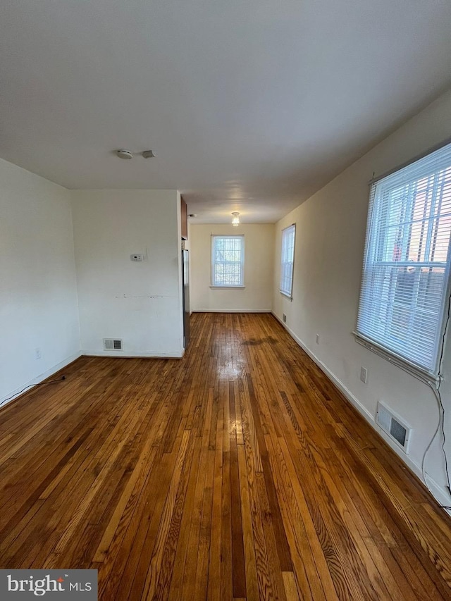 spare room with hardwood / wood-style floors and a healthy amount of sunlight