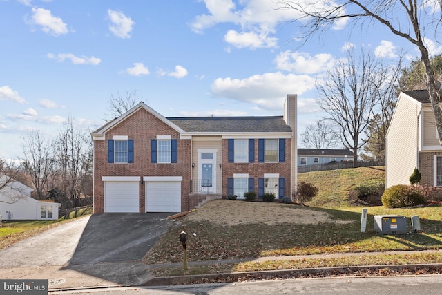 split foyer home with a front yard and a garage