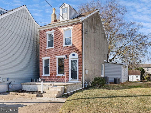 view of front of property with central air condition unit and a front yard